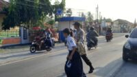 Jamin Keselamatan Siswa, Anggota Polsek Ampana Kota Bantu Seberangkan Jalan Ke Sekolah