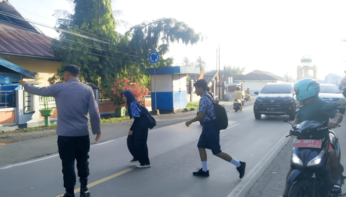 Pelayanan Prima Di Pagi Hari, Polsek Ampana Kota Bantu Siswa SMP Menyebrang Jalan