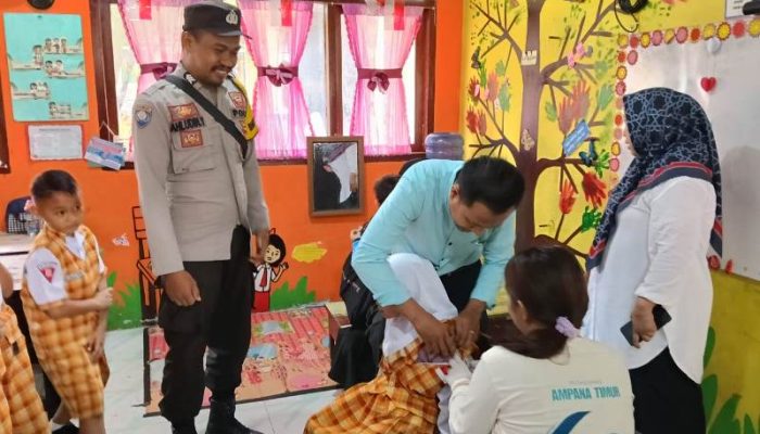Peduli Kesehatan Generasi Bangsa, Bhabinkamtibmas Polsek Ampana Kota Dampingi Vaksinasi Campak di SDN 1 Ratolindo